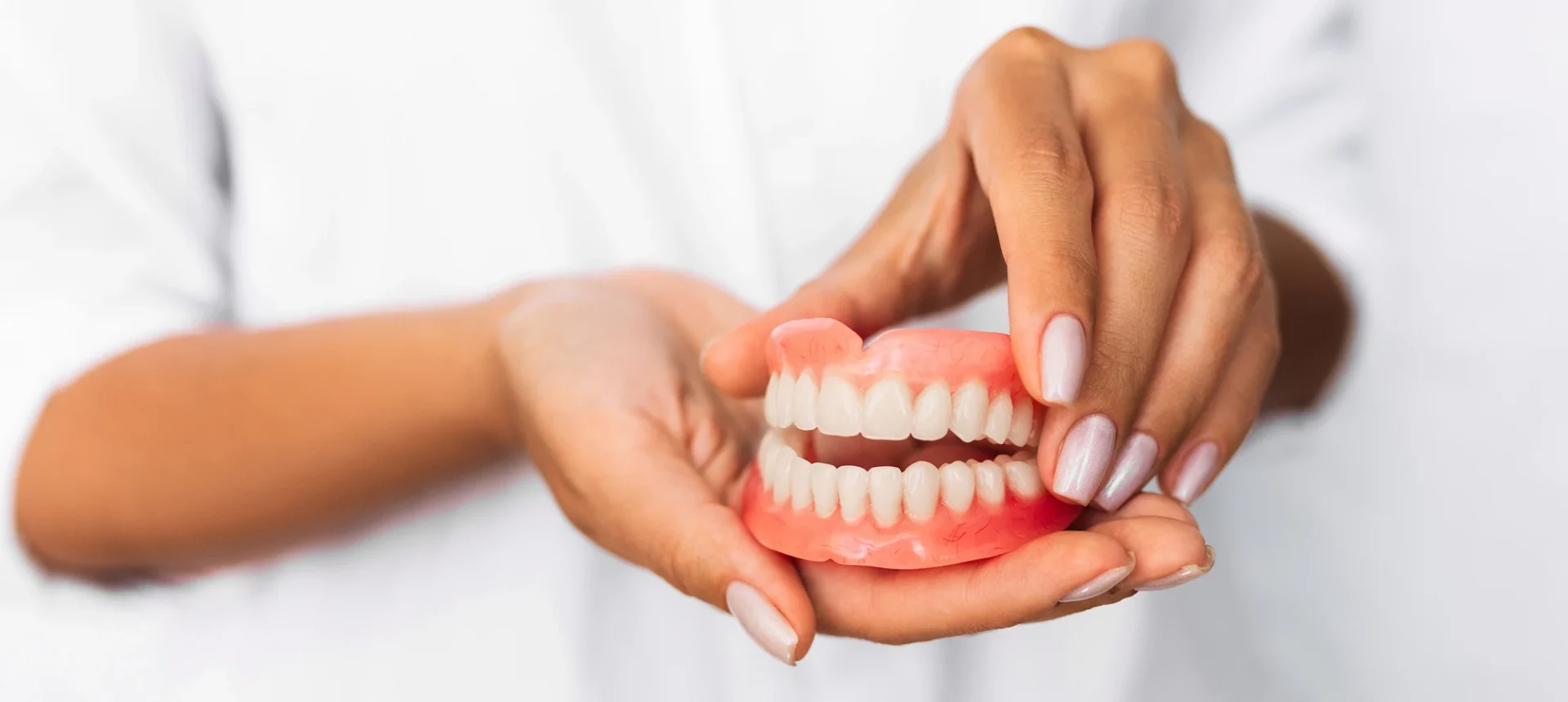 dentist holding dentures in Cary