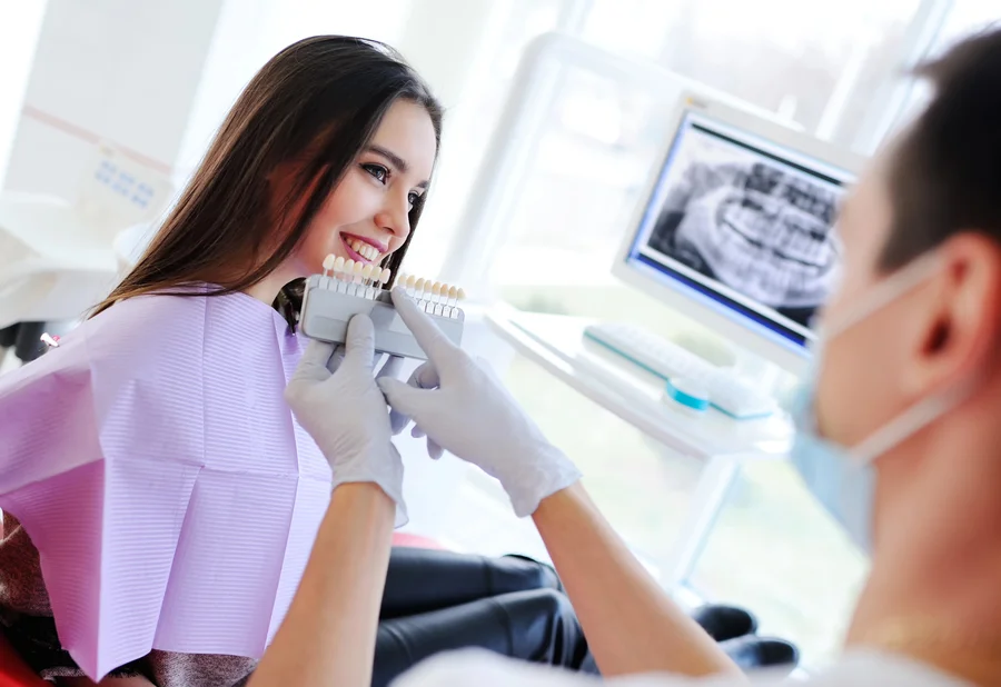 dentist-in-morrisville-comparing-tooth-shade-guide-with-patient-smile